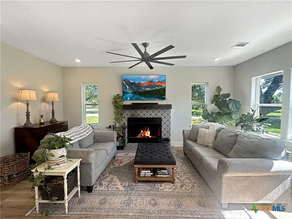 a living room with furniture a rug and a fireplace