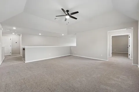 an empty room with a ceiling fan and a window