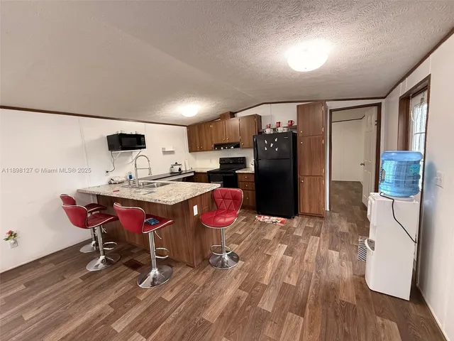 a kitchen with stainless steel appliances granite countertop a refrigerator and a sink