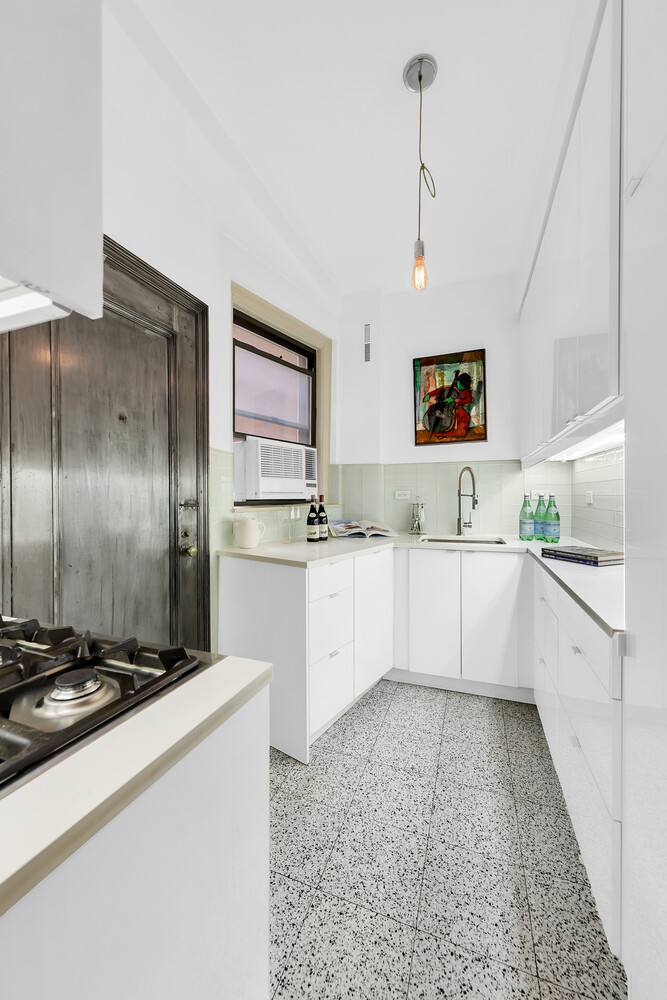 175 East 79th Street, Unit 2C Manhattan, NY 10075 - Photo 13 of 17 a large kitchen with kitchen island white cabinets and stainless steel appliances