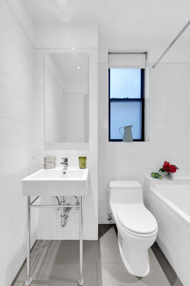 175 East 79th Street, Unit 2C Manhattan, NY 10075 - Photo 16 of 17 a white toilet sitting next to a bathroom sink