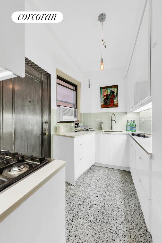 175 East 79th Street, Unit 2C Manhattan, NY 10075 - Photo 7 of 17 a large kitchen with kitchen island a sink stainless steel appliances and a counter top