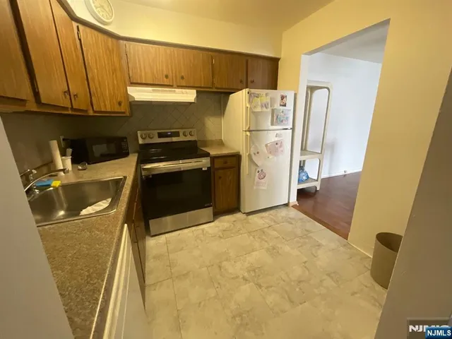 a kitchen with refrigerator a stove a washer and dryer