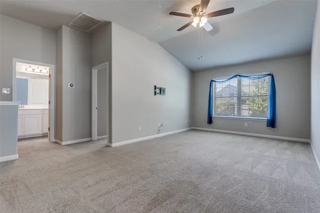an empty room with windows and ceiling fan