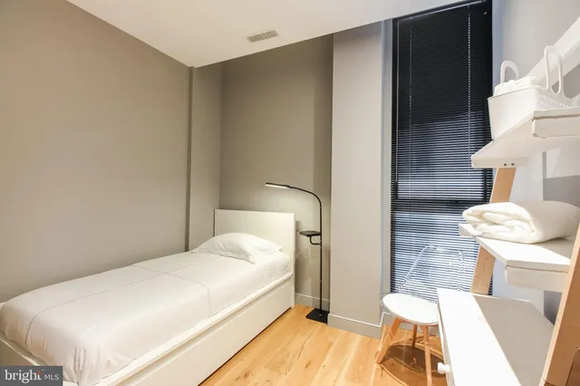 a bedroom with a bed and wooden floor