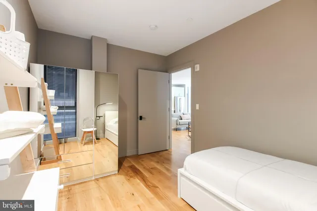 a bedroom with a bed and wooden floor