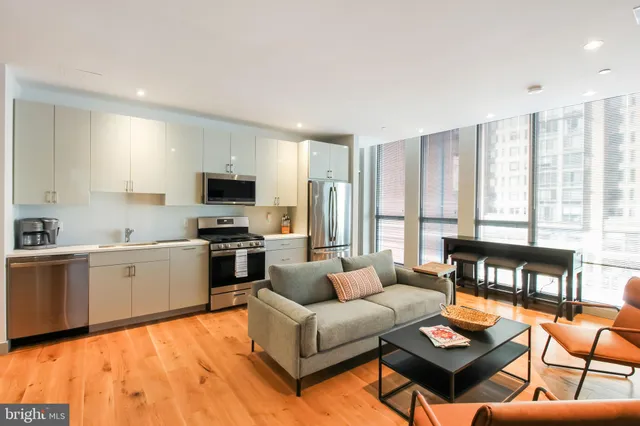 a living room with furniture and kitchen view