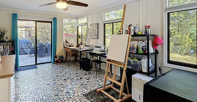 a view of a workspace with furniture and a window