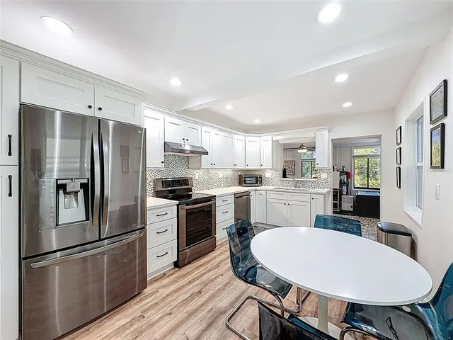 a kitchen with refrigerator cabinets dining table and chairs