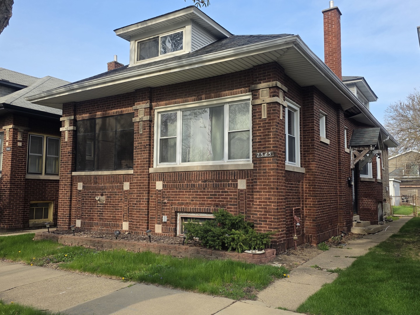 a front view of a house with a garden