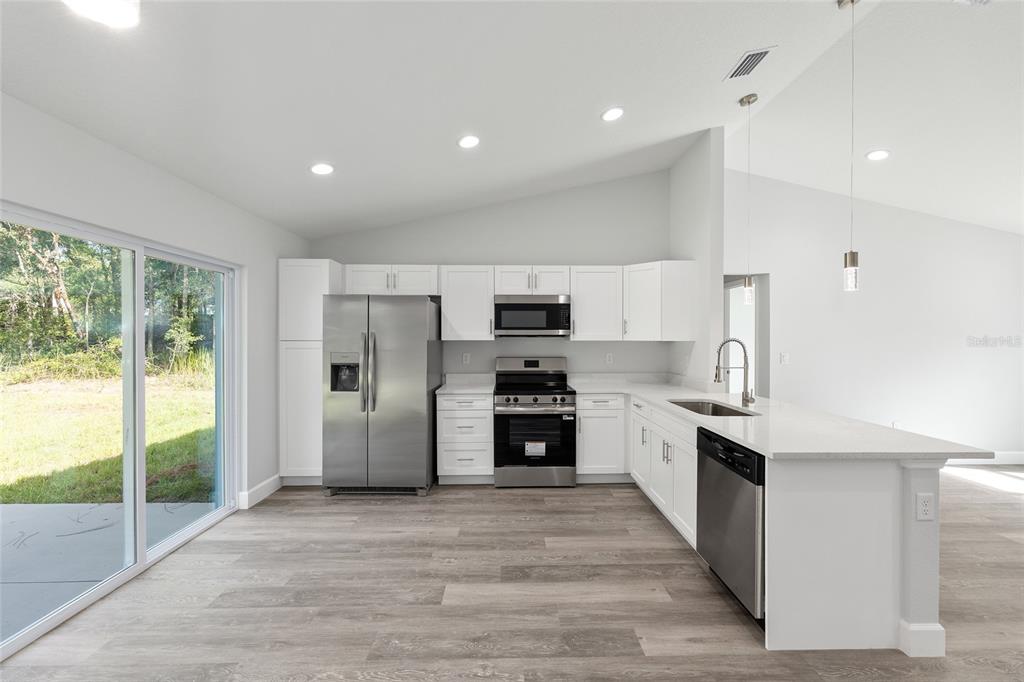 2130 Southwest 159th Court Ocala, FL 34481 - Photo 14 of 27 a kitchen with stainless steel appliances granite countertop a stove top oven a sink and a refrigerator