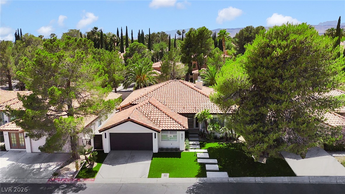 8981 Rivers Edge Drive Las Vegas, NV 89117 - Photo 4 of 69 A terracotta-tiled roof crowns this residence, featuring a lush green lawn and an attached garage.