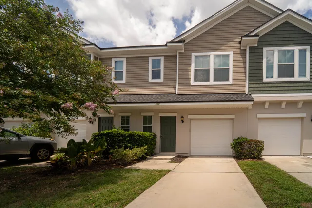 a front view of a house with a garden and yard