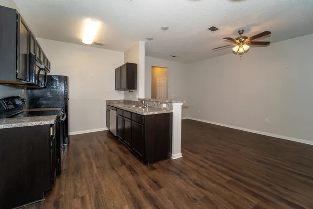 a kitchen with stainless steel appliances granite countertop a stove cabinets and wooden floor