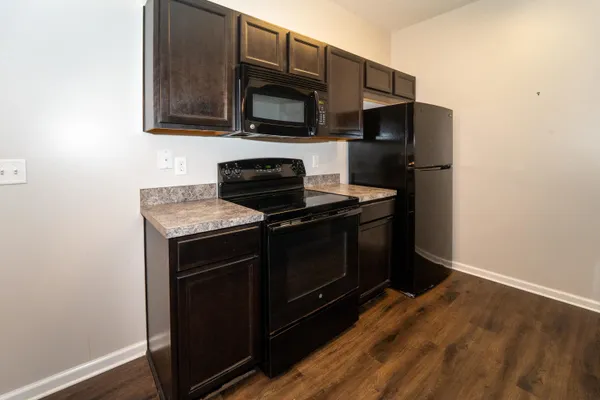 a kitchen with stainless steel appliances granite countertop a stove microwave and refrigerator