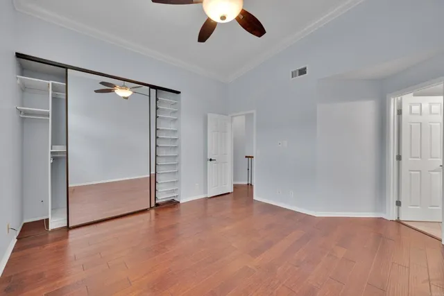 wooden floor in an empty room with a ceiling fan