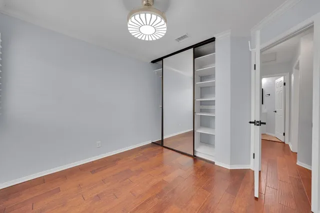 a view of empty room with wooden floor