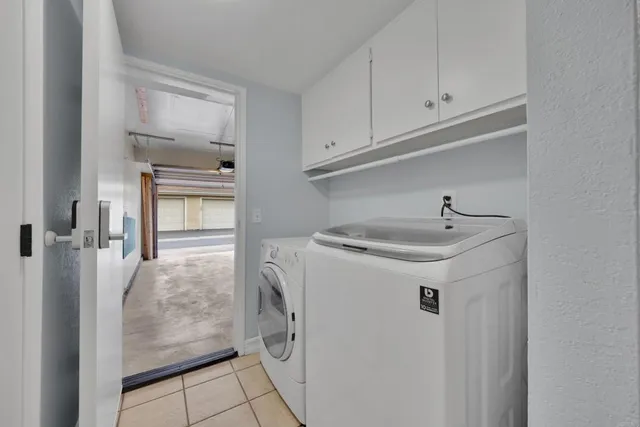 a utility room with cabinets washer and dryer