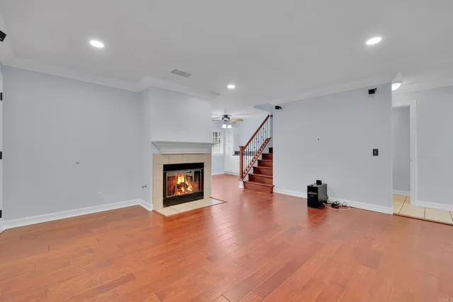 a view of an empty room with wooden floor a fireplace