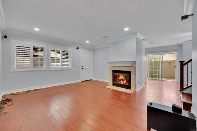 a view of a livingroom with wooden floor and a fireplace