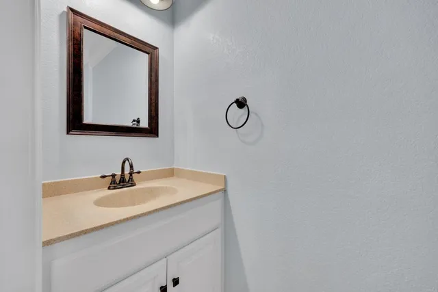 a bathroom with a sink mirror and vanity