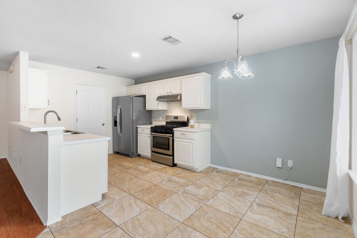 1700 Canon Yeomans Trail Austin, TX 78748 - Photo 13 of 32 a kitchen with a stove a sink and a refrigerator