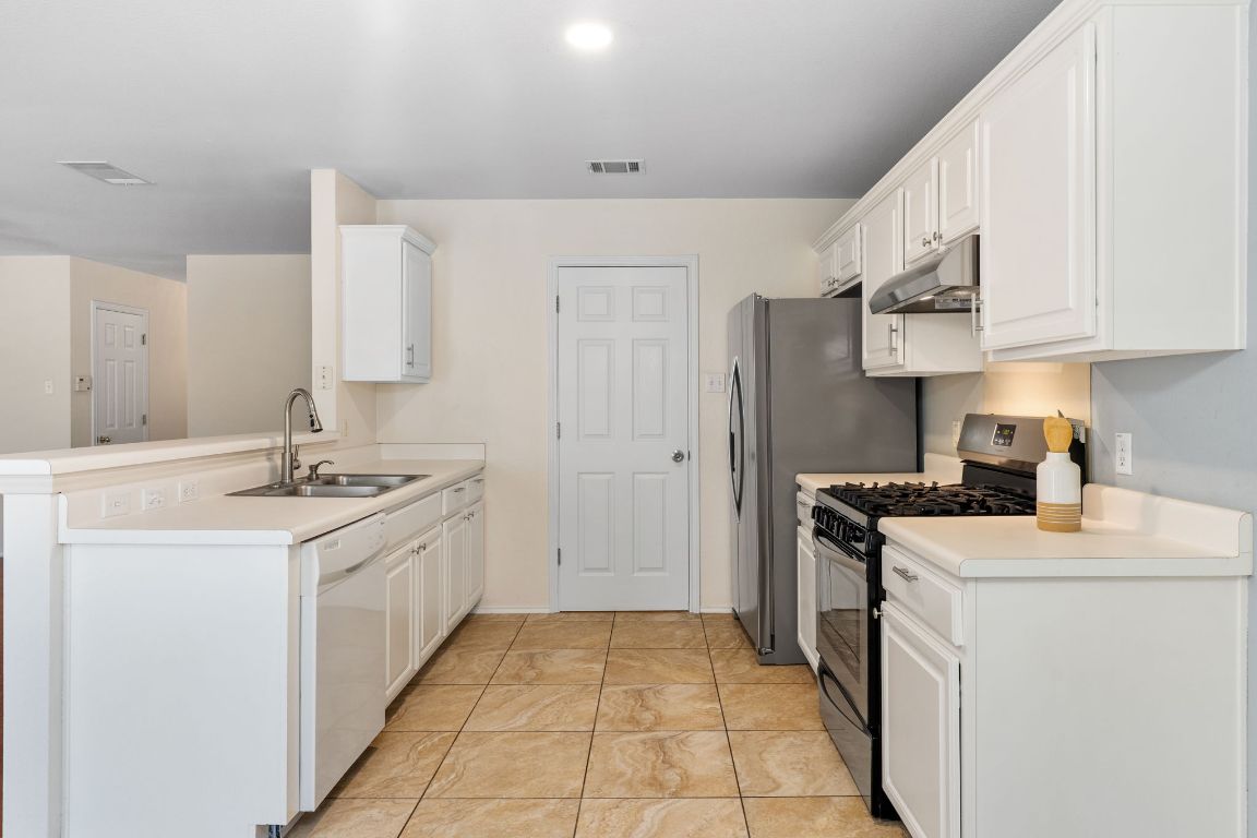 1700 Canon Yeomans Trail Austin, TX 78748 - Photo 15 of 32 a kitchen with stainless steel appliances granite countertop a sink stove and refrigerator