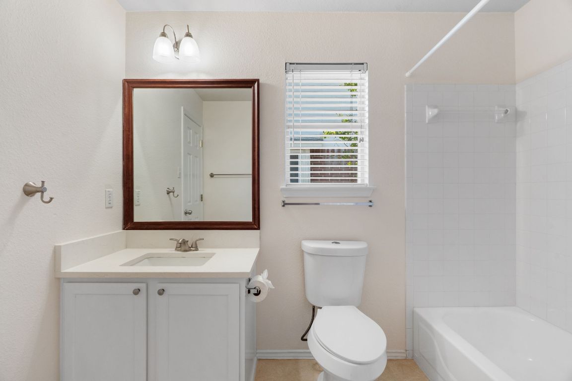 1700 Canon Yeomans Trail Austin, TX 78748 - Photo 23 of 32 a bathroom with a toilet a sink a mirror and a bathtub