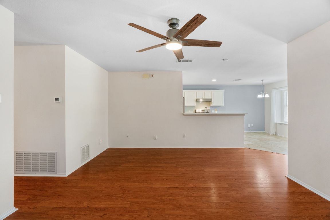 1700 Canon Yeomans Trail Austin, TX 78748 - Photo 9 of 32 an empty room with wooden floor and ceiling fan