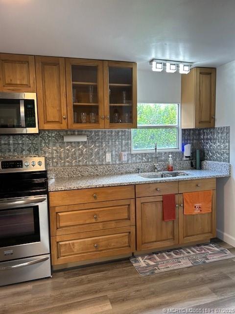 1944 Southwest College Street Stuart, FL 34997 - Photo 3 of 50 a kitchen with granite countertop wooden cabinets stainless steel appliances and a sink