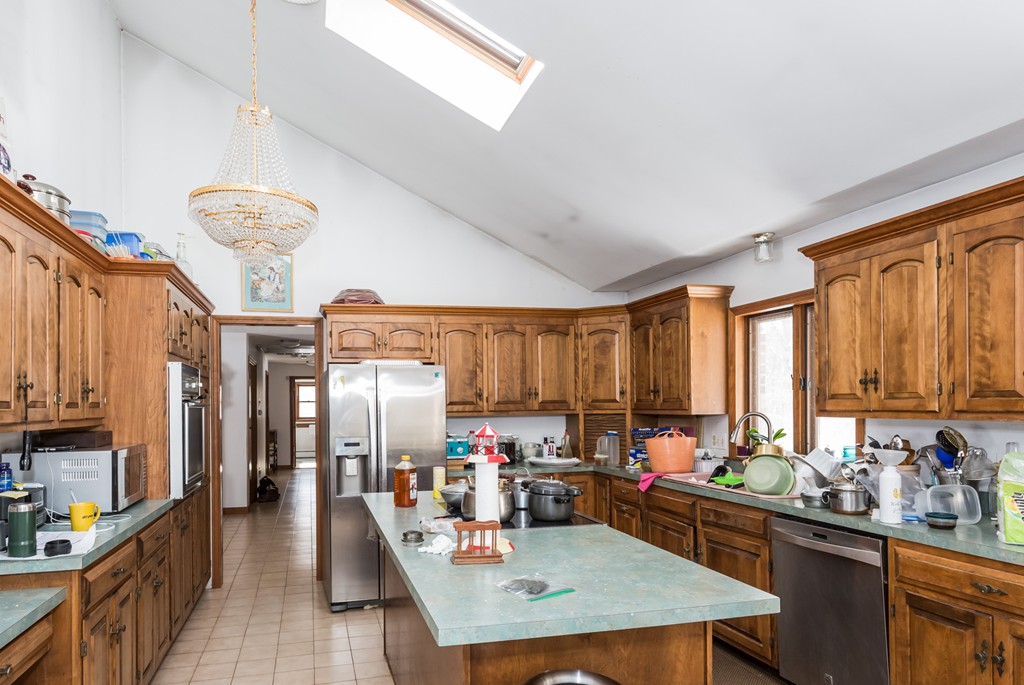 125 Bennett Road Hampden, MA 01036 - Photo 14 of 23 a kitchen with stainless steel appliances kitchen island granite countertop a refrigerator a sink dishwasher a dining table and chairs with wooden floor