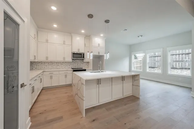a kitchen with kitchen island white cabinets appliances and sink