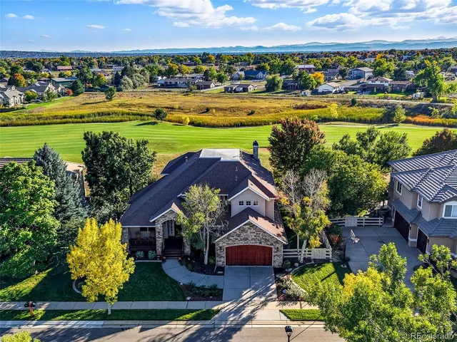 a front view of a house with a yard and lake view