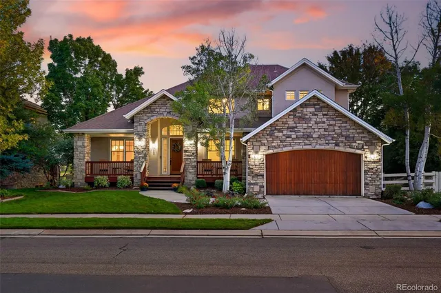 a view of a house with a yard plants and large tree
