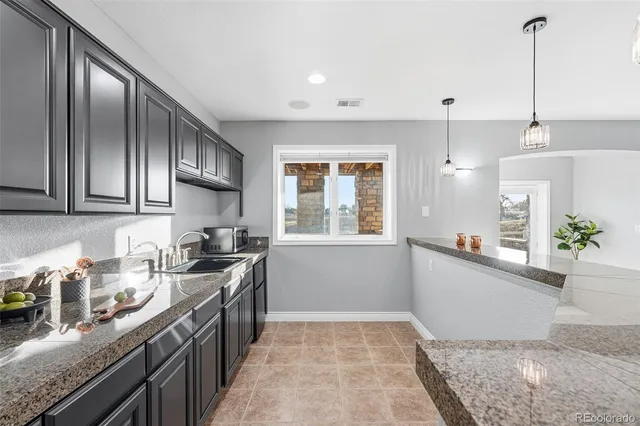 a bathroom with a granite countertop toilet sink and mirror