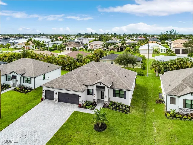an aerial view of a house with yard swimming pool and green space