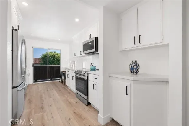 a kitchen with white cabinets and stainless steel appliances