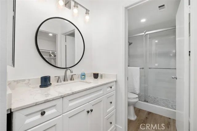 a bathroom with a toilet a sink a mirror and shower