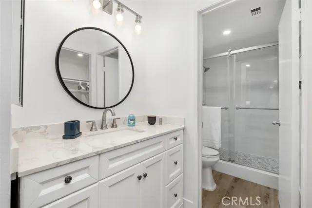 a bathroom with a toilet a sink a mirror and shower