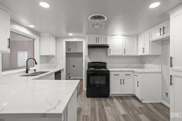a kitchen with granite countertop a sink stainless steel appliances and cabinets