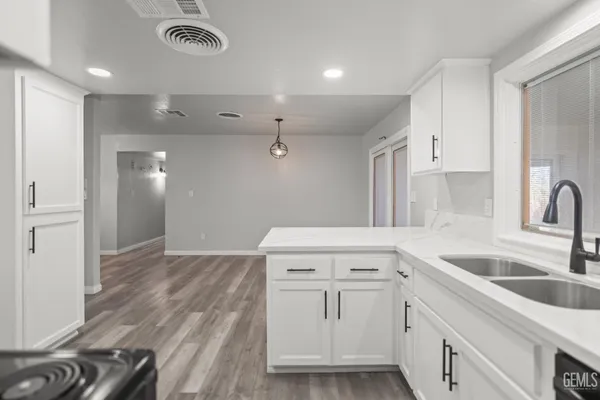 a kitchen with a sink cabinets and wooden floor