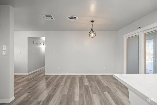 a view of a room with wooden floor and fan