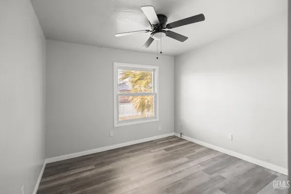 an empty room with a window and a ceiling fan