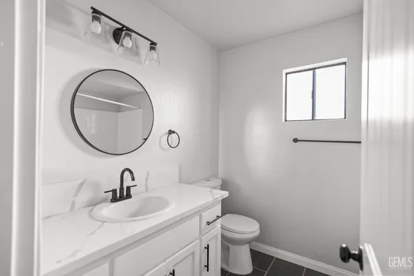 a bathroom with a toilet a sink and mirror