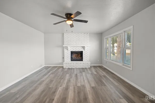an empty room with windows fireplace and a sink