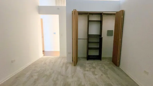 an empty room with closet and a bathroom