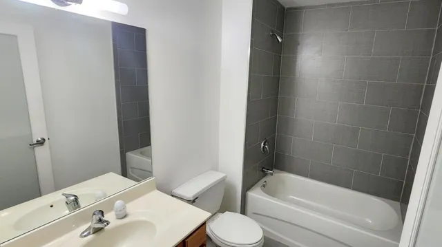 a bathroom with a bathtub shower sink vanity and toilet