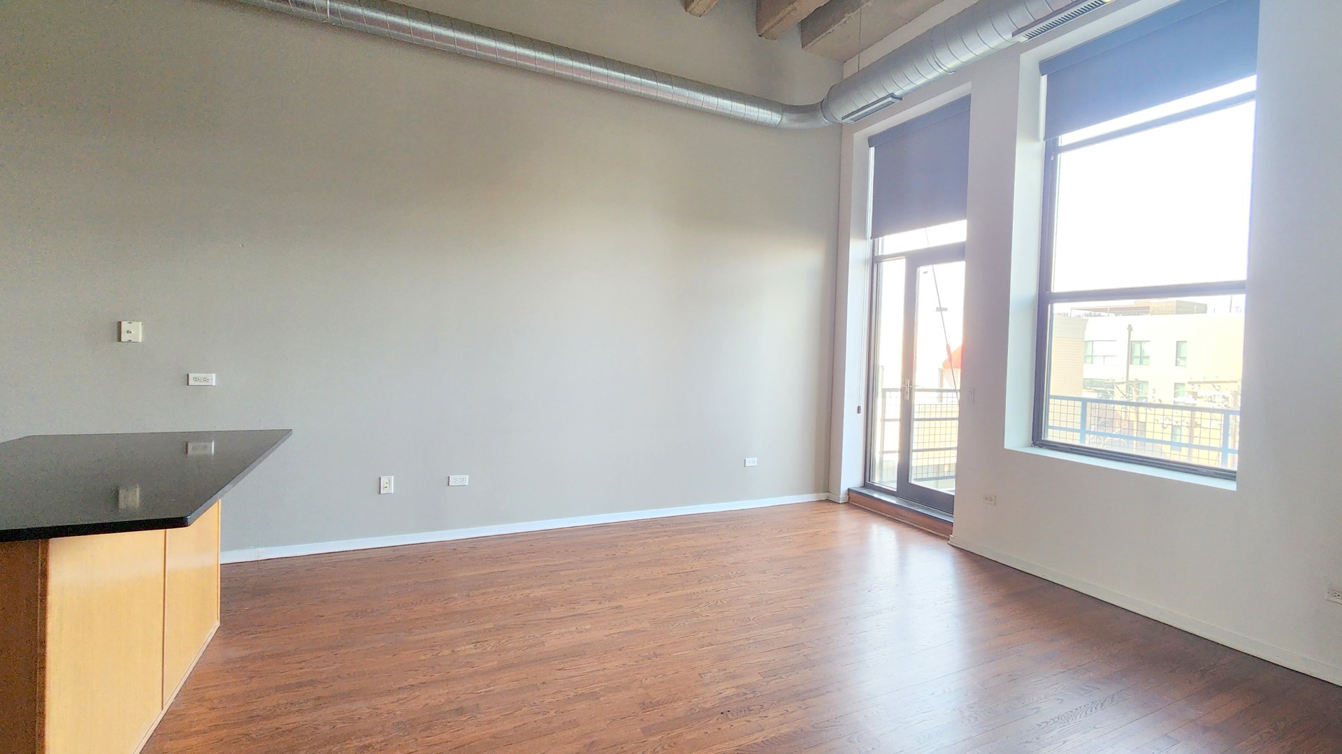 1645 West Ogden Avenue, Unit 417 Chicago, IL 60612 - Photo 4 of 19 an empty room with wooden floor and windows