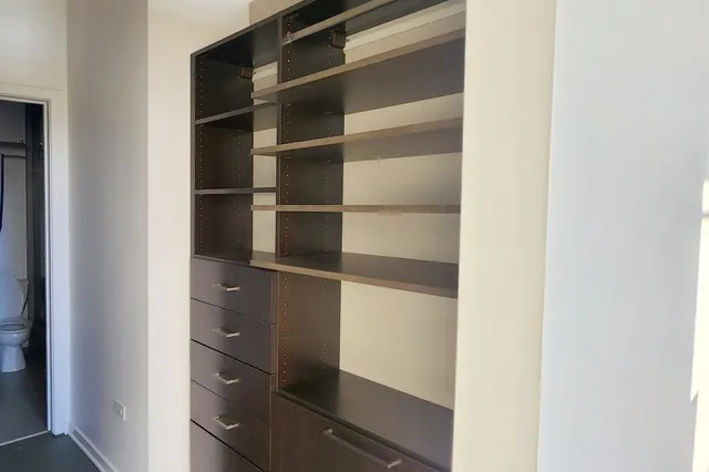 a view of walk in closet with empty racks