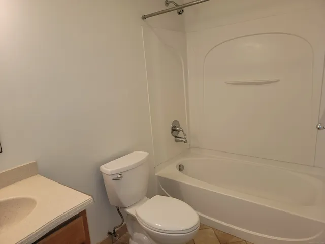 a white toilet sitting next to a bath tub